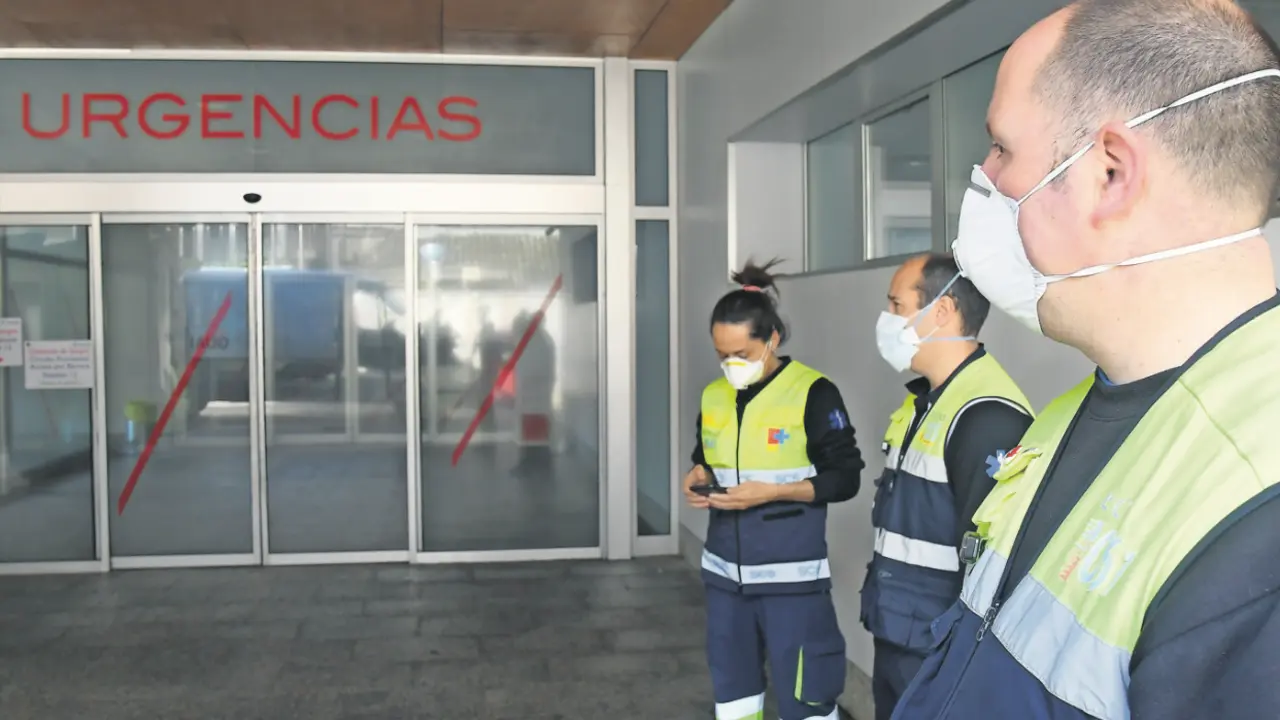 Trabajadores sanitarios ante la puerta de Urgencias de Valdecilla. / CubErO