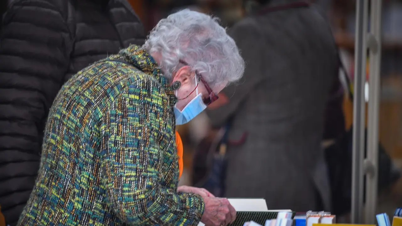 Una persona de avanzada edad ojea un libro en una librer&iacute;a de Santander. / HARDY