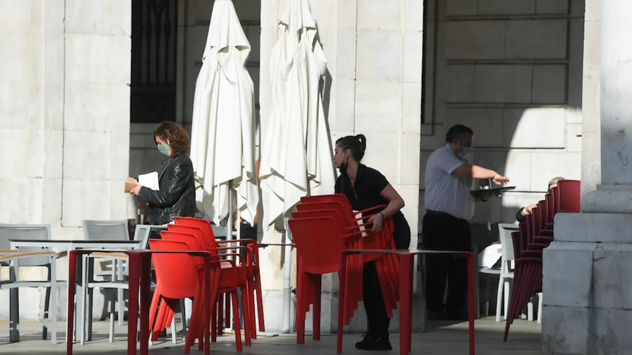 Una trabajadora del sector servicios prepara las mesas en la plaza Porticada de Santander. / HARDY