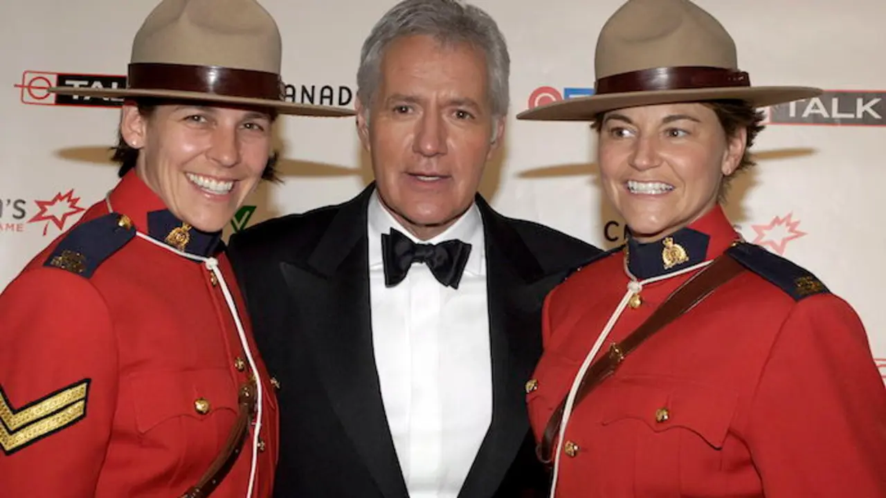 El presentador del programa de juegos de televisi&oacute;n Alex Trebek (C) posa con las Mounties canadienses Mia Poscente (L) y April Dequanne en el backstage en la novena ceremonia anual del Paseo de la Fama de Canad&aacute; en Toronto. / EFE / WARREN TODA