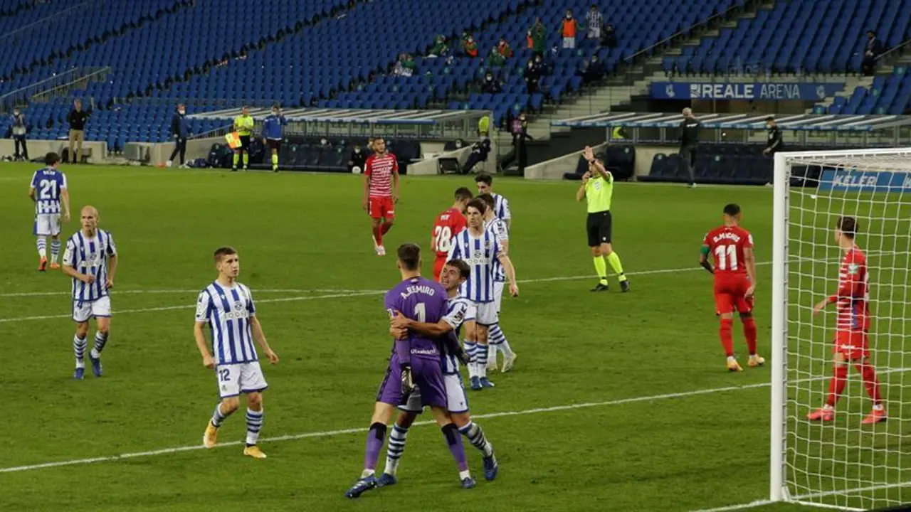 El portero de la Real Sociedad, Alex Remiro, es felicitado tras detener un penalti ante el Granada, durante el partido de la novena jornada de LaLiga Santander que han disputado este domingo en el estadio Reale Arena de San Sebasti&aacute;n. EFE/Javier Etxezarreta