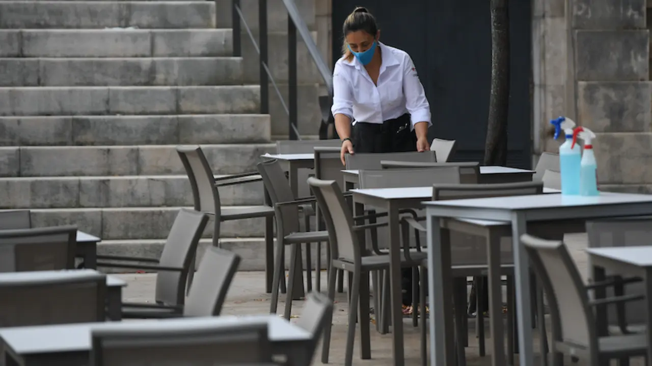 Una trabajadora de la hosteler&iacute;a prepara las mesas antes de empezar la jornada. / Hardy
