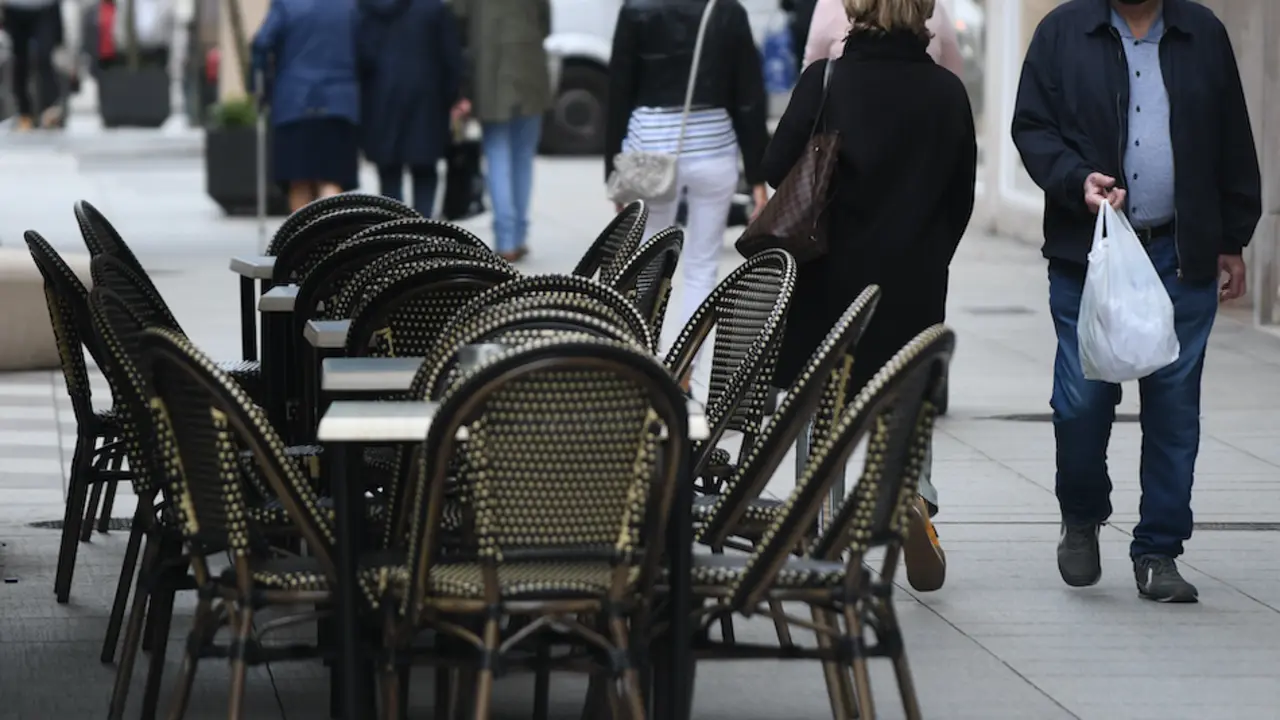 Una persona observa las mesas vac&iacute;as de un establecimientos hostelero en el Paseo Pereda de Santander. / HARDY