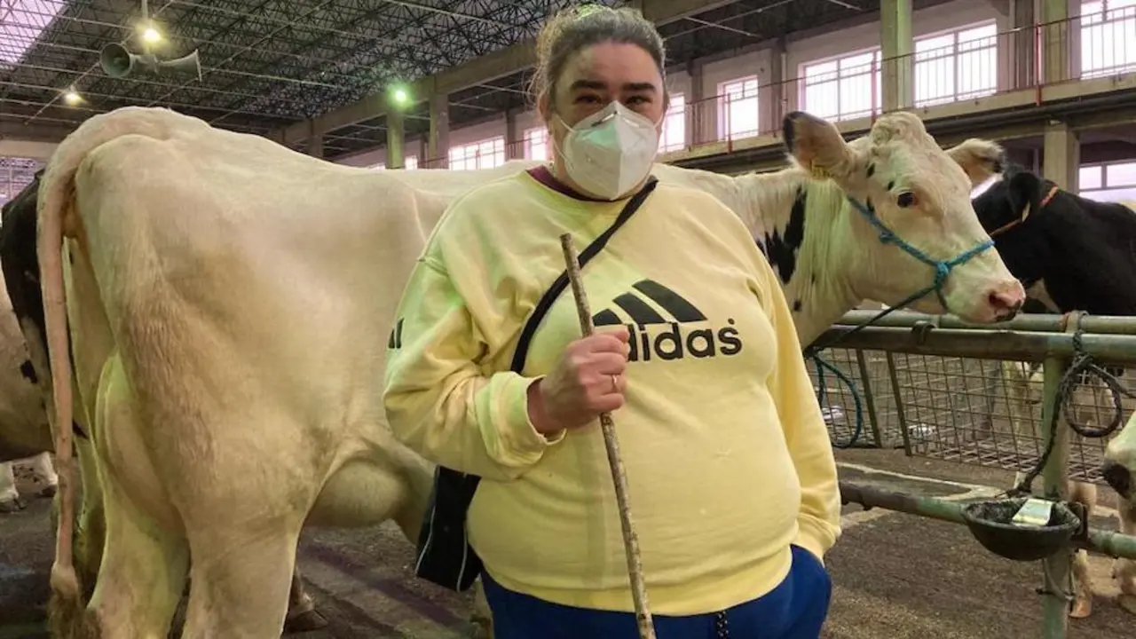 Rosario, ganadera de Vega de Pas, junto a sus novillas frisonas ayer en la feria semanal del Mercado Nacional de Ganados de Torrelavega. / ALERTA