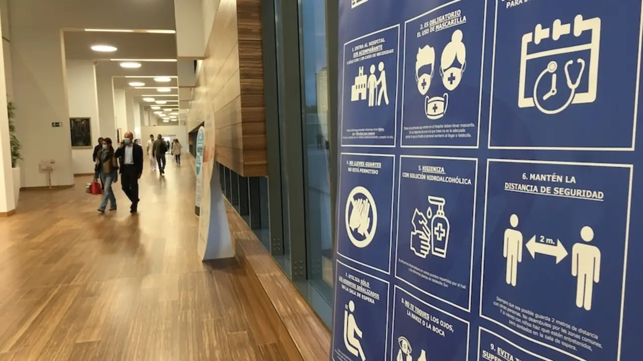 Un cartel con las medidas de prevenci&oacute;n sanitarias en la entrada del Hospital Marqu&eacute;s de Valdecilla. / S.D.