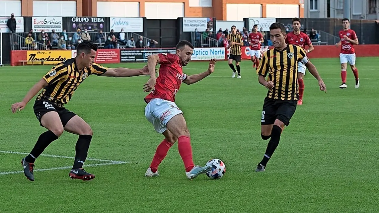 Un jugador del Laredo controla el bal&oacute;n ante la presi&oacute;n de un rival. / reguera