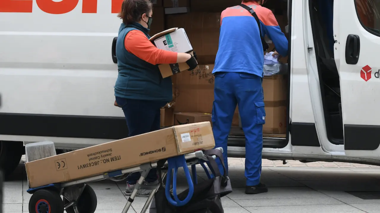 Dos trabajadores de reparto durante su jornada en la ciudad de Santander. / HARDY