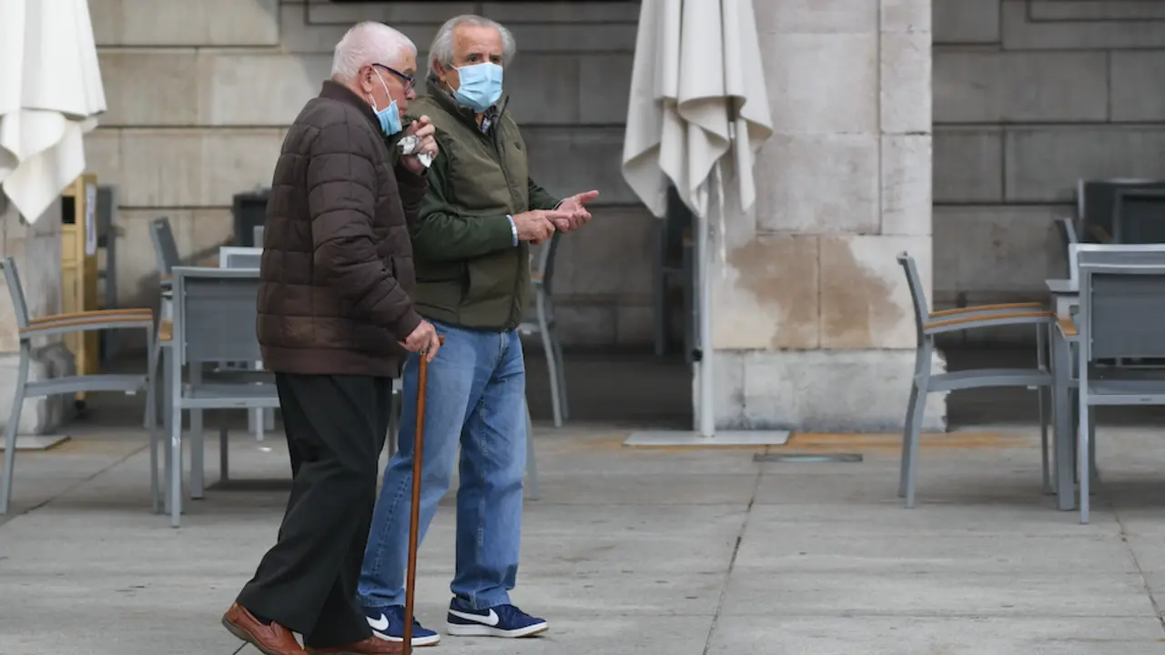 Dos personas de avanzada edad pasean por la plaza Porticada de Santander. / HARDY