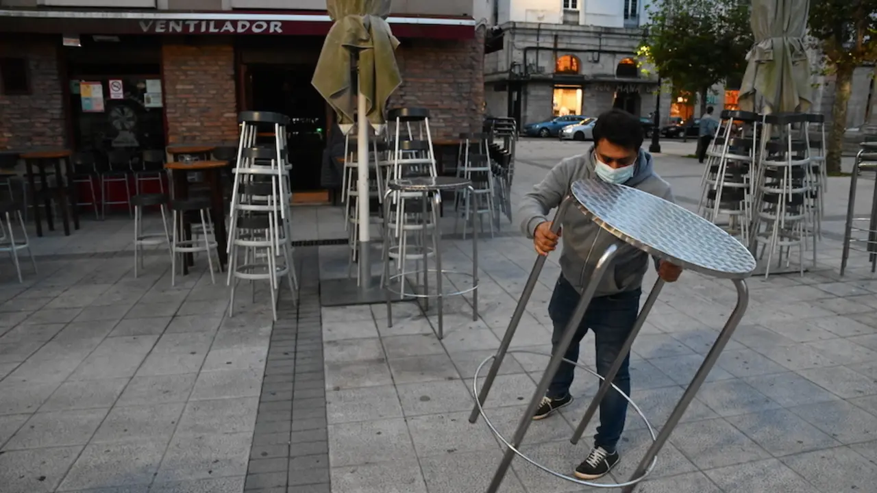 Un trabajador de la hosteler&iacute;a coloca las mesas para iniciar su jornada en la Plaza de Ca&ntilde;ad&iacute;o de Santnader. / HARDY