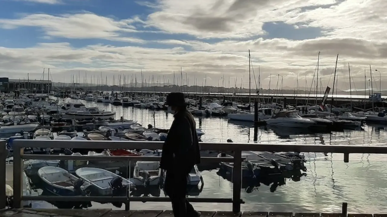Una persona de avanzada edad camina frente a Puertochico en Santander. / S.D.