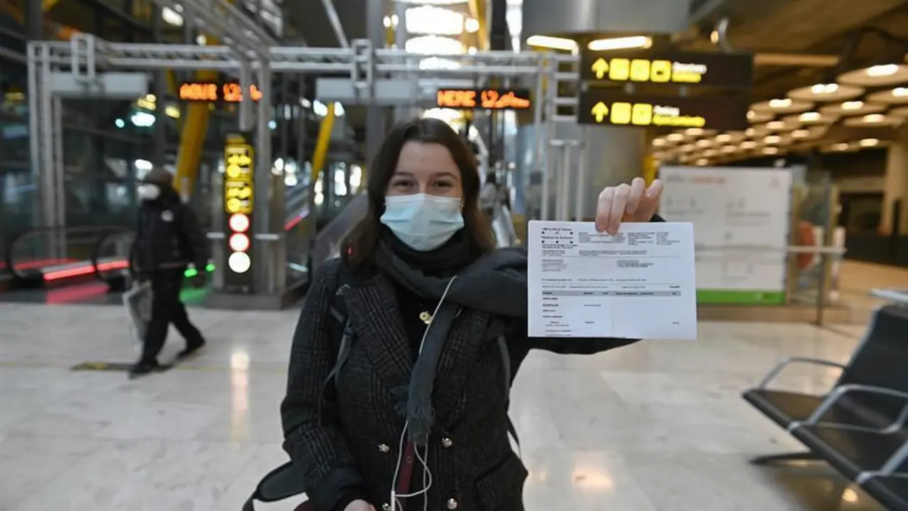 Una joven muestra el resultado de su PCR a su llegada al aeropuerto Adolfo Su&aacute;rez-Barajas en Madrid, este lunes, donde comienza la exigencia de pruebas PCR para pasajeros de vuelos procedentes de pa&iacute;ses de riesgo. Las medidas que entran este lunes en vigor se suman a los controles que se llevan a cabo actualmente a todos los pasajeros internacionales en los puntos de entrada, de tal manera que se mantiene el control de temperatura, el control visual y el control documental, seg&uacute;n la normativa establecida por el Ministerio de Sanidad.Los aeropuertos, adem&aacute;s, seguir&aacute;n recordando por megafon&iacute;a y con carteles luminosos la necesidad de llevar mascarilla y de cumplir las medidas higi&eacute;nicas requeridas por las autoridades sanitarias. EFE/ Fernando Villar