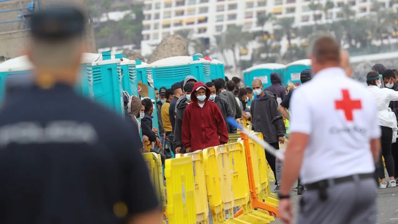Varios inmigrantes aguardan este martes en el muelle de Arguinegu&iacute;n. / EFE