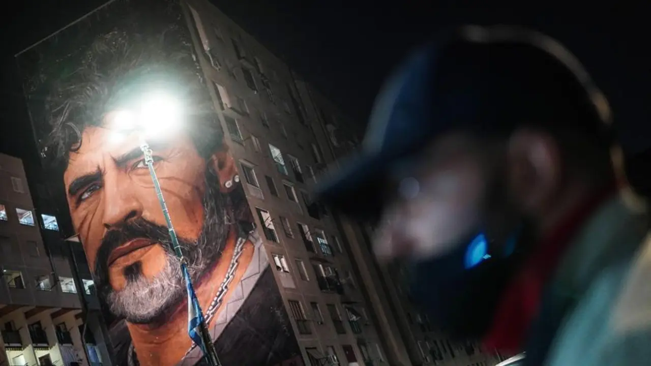 La gente rinde homenaje al ex jugador de f&uacute;tbol argentino y ex jugador del Napoli Diego Maradona cerca del mural de Jorit en San Giovanni al Teduccio, un distrito de la zona este de N&aacute;poles, Italia, el 25 de noviembre de 2020. Diego Maradona ha muerto despu&eacute;s de un ataque card&iacute;aco, informan los medios reclamado el 25 de noviembre de 2020. (Atentado, Italia, N&aacute;poles) EFE / EPA / CESARE ABBATE