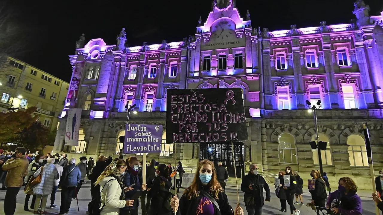 Una mujer con una pancarta anoche ante el consistorio santanderino. / Hardy