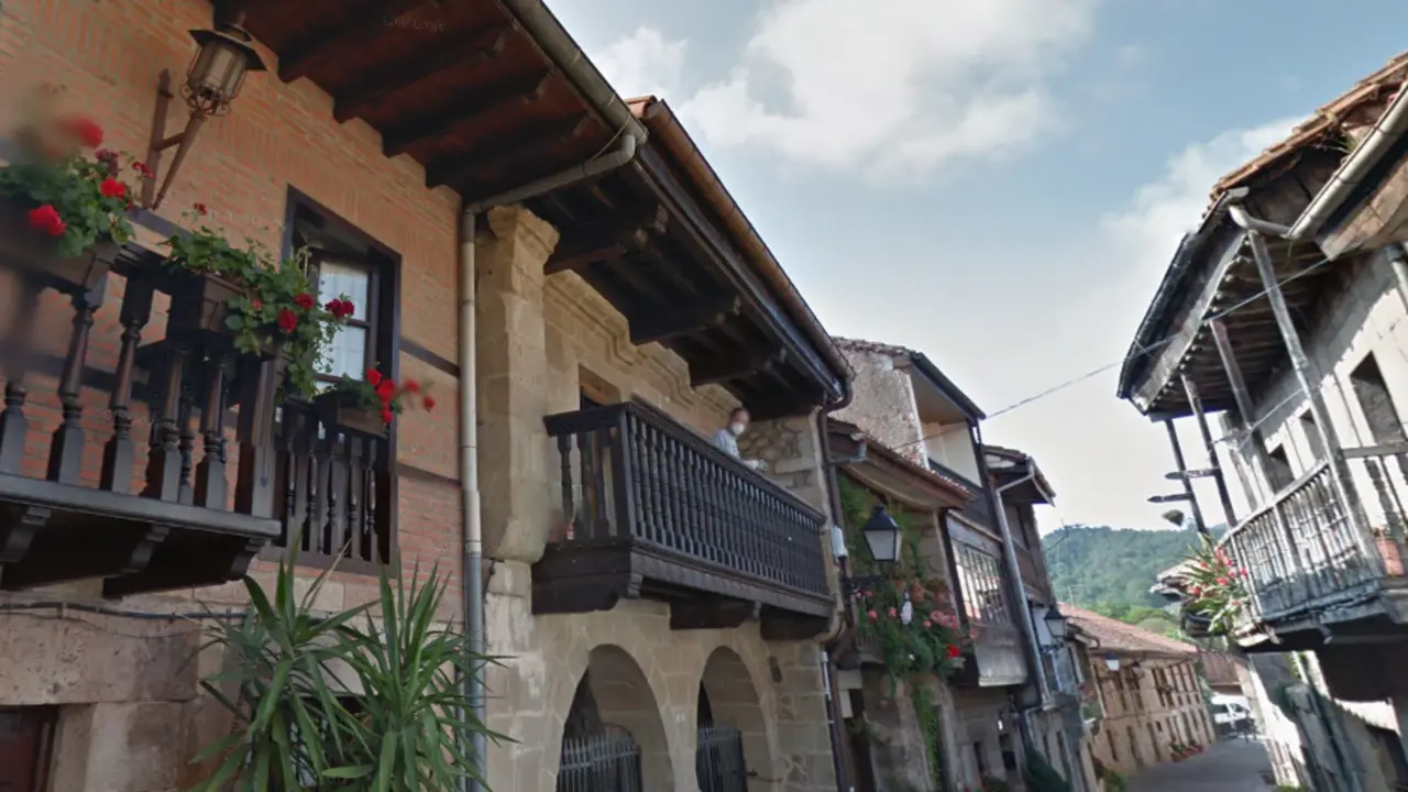 Un vecino de cartes con mascarilla observa al fot&oacute;grafo en la calle Camino Real de Cartes. / ALERTA