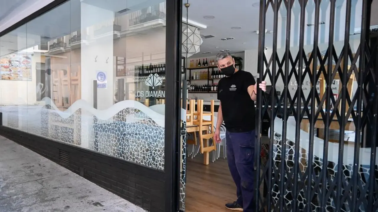 Un empleado cierra la persiana de un bar en el centro de la capital granadina. EFE/Miguel &Aacute;ngel Molina/Archivo