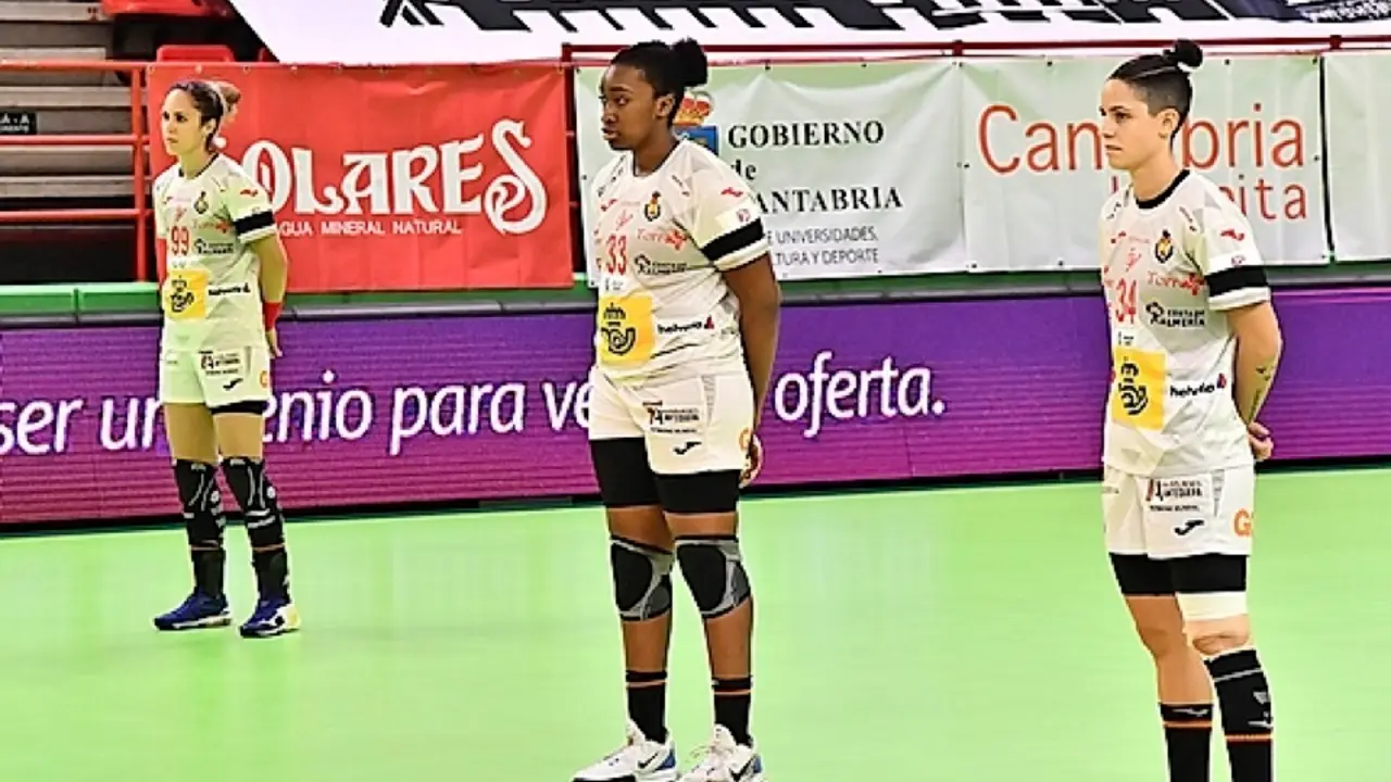 Las jugadoras de la selecci&oacute;n espa&ntilde;ola, M. Gonz&aacute;lez, K. Gassama y A. Fern&aacute;ndez, durante el minuto de silencio en recuerdo de Juan de Dios Rom&aacute;n, el domingo antes de iniciarse el partido en Torrelavega. / RFEBM