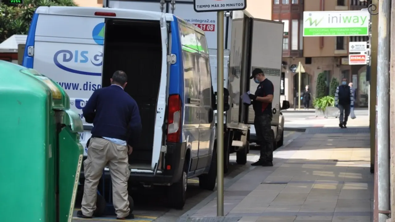 Varios trabajadores de reparto estacionados en una calle en Torrelavega. / S.D.