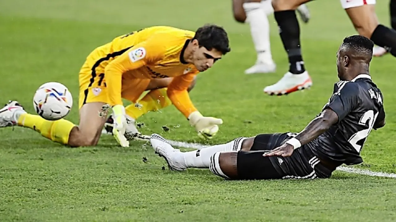 GRAF904. SEVILLA, 05/12/2020- El delantero brasile&ntilde;o del Real Madrid, Vinicius Junior, efect&uacute;a un lanzamiento que el portero marroqu&iacute; del Sevilla Yassine Bounou (i) introduce en su propia porter&iacute;a en el primer gol del equipo durante el partido de LaLiga disputado este s&aacute;bado en el estadio S&aacute;nchez Pizju&aacute;n. EFE/Jose Manuel Vidal.