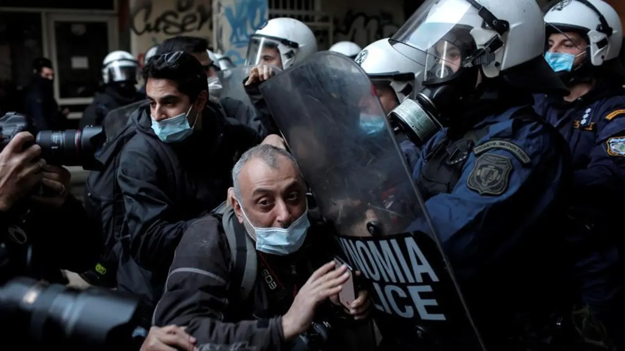 Los agentes de polic&iacute;a hacen retroceder a los fot&oacute;grafos de un sitio donde los manifestantes permanecen atrapados en un edificio durante una operaci&oacute;n policial de vigilancia de una manifestaci&oacute;n que marca el 12 &deg; aniversario del asesinato del adolescente Alexis Grigoropoulos, en Atenas, Grecia, el 6 de diciembre de 2020. Grigoropoulos, 15 a&ntilde;os -viejo estudiante, fue asesinado el 6 de diciembre de 2008 en un aparente tiroteo policial en el centro de Atenas, hecho que provoc&oacute; disturbios en la capital griega. Se esperaban protestas a pesar de la prohibici&oacute;n actual de las reuniones. (Protestas, Grecia, Atenas) EFE / EPA / KOSTAS TSIRONIS