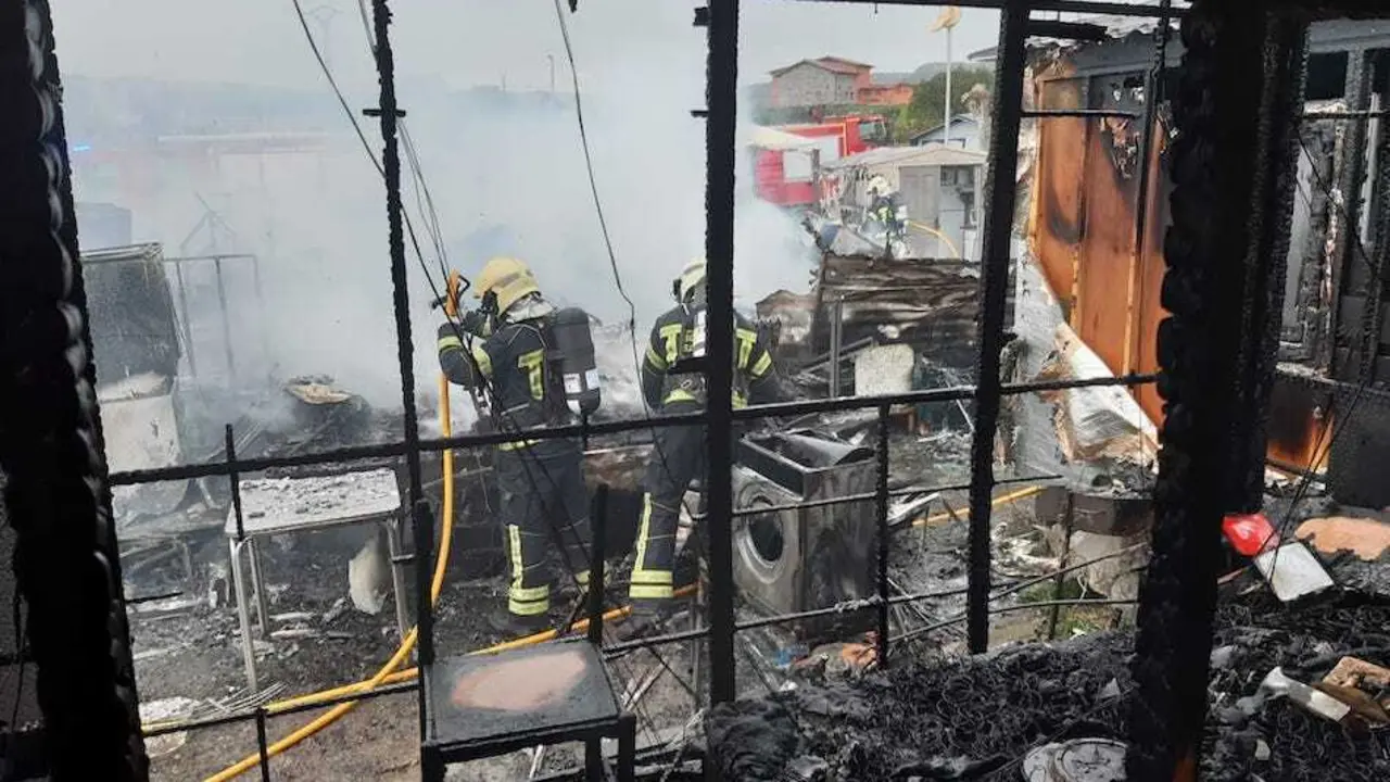 Vista de los trabajos de los bomberos en el incendio camping Ajo.