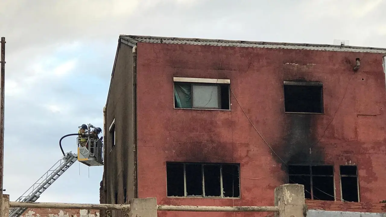 Trabajos de extinci&oacute;n del incendio de una nave en Badalona