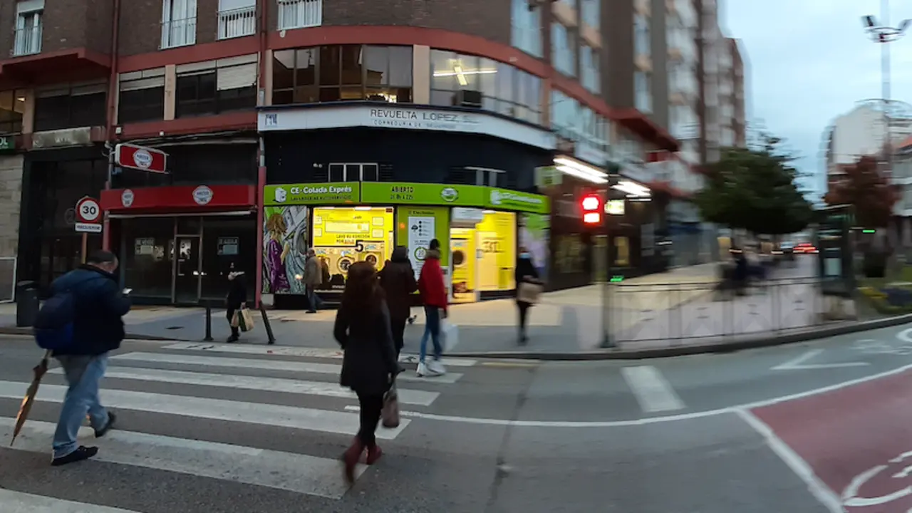 Varias personas cruzan la calle Jos&eacute; Posada Herrera junto a unos comercios cerrados. / S.D.