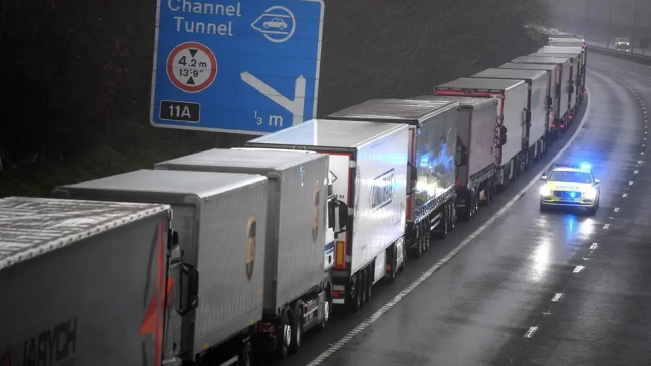 Un coche de polic&iacute;a pasa junto a una larga cola de camiones que permanecen atrapados a causa del cierre de la frontera con Reino Unido decretada por Francia, este lunes en Kent, Reino Unido. EFE/Neil Hall