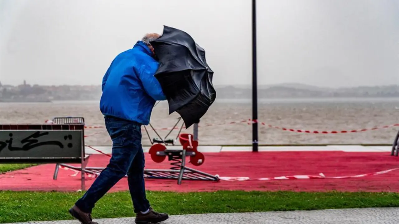 Un hombre sujeta con fuerza su paraguas mientras camina este lunes por la bah&iacute;a de Santander. Cantabria permanece en alerta por fuertes vientos y oleaje debido a la borrasca "Bella". EFE/Rom&aacute;n G. Aguilera