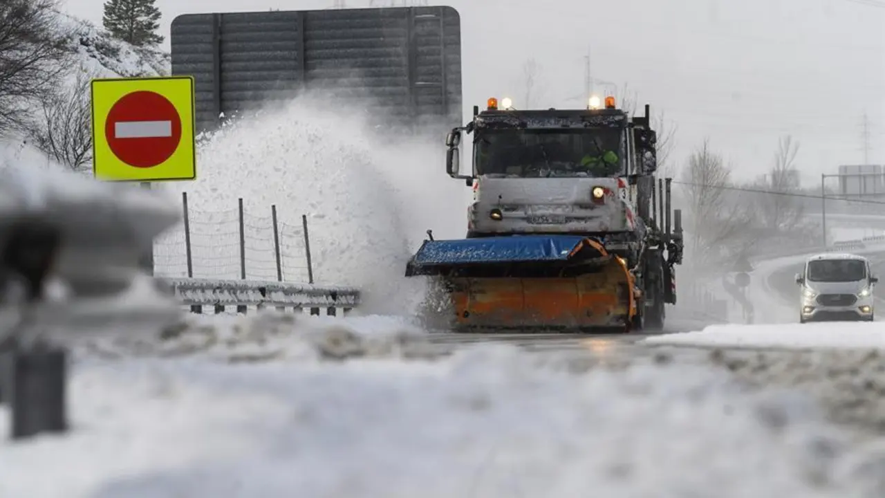 Una m&aacute;quina quitanieves limpia la A-67 tras una nevada por la que varios camiones permanecen en un atasco este s&aacute;bado en la localidad c&aacute;ntabra de Arenas de Igu&ntilde;a. EFE/Pedro Puente Hoyos