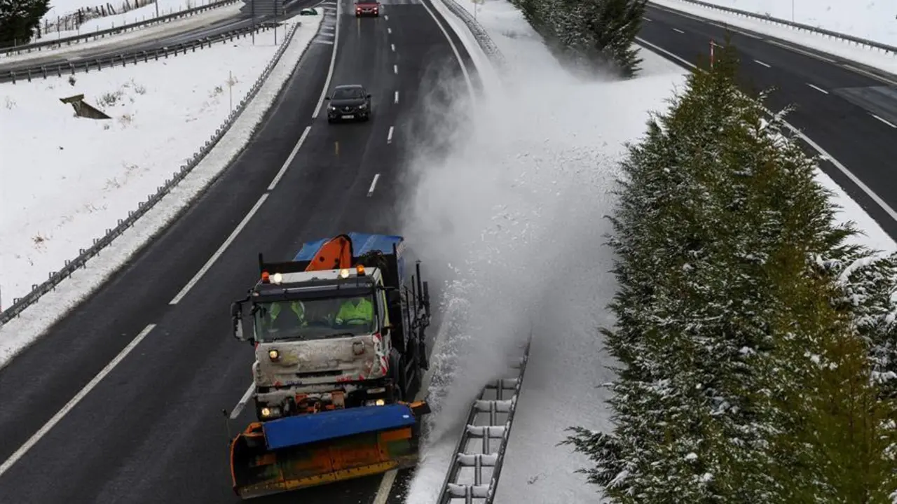 Una m&aacute;quina quitanieves limpia la A-67 tras una nevada por la que varios camiones permanecen en un atasco este s&aacute;bado en la localidad c&aacute;ntabra de Arenas de Igu&ntilde;a. EFE/Pedro Puente Hoyos