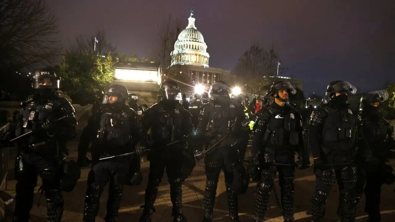 Oficiales de polic&iacute;a con equipo antidisturbios se alinean frente al Capitolio despu&eacute;s de ser invadido por una turba violenta. Tasos Katopodis/Getty Images