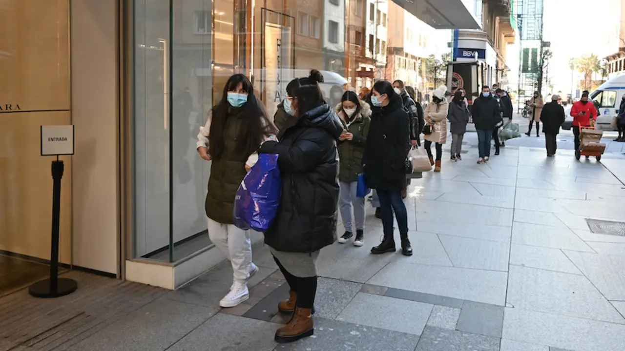 Varias personas esperan en la entrada de un comercio del centro de Santander. / Hardy