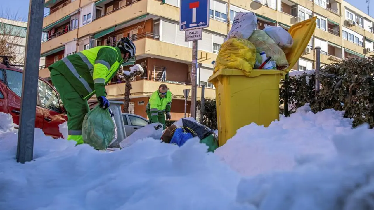 Operarios del servicio de limpieza retiran los cubos de basura de las calles de Madrid tras reiniciarse ayer el servicio de recogida suspendido tras el paso de la borrasca Filomena. EFE/Rodrigo Jim&eacute;nez.