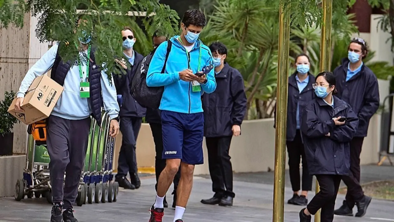 El tenista brasile&ntilde;o Marcelo Melo es escoltado desde su habitaci&oacute;n de hotel hasta la pista de entrenamiento en Melbourne. / EFE
