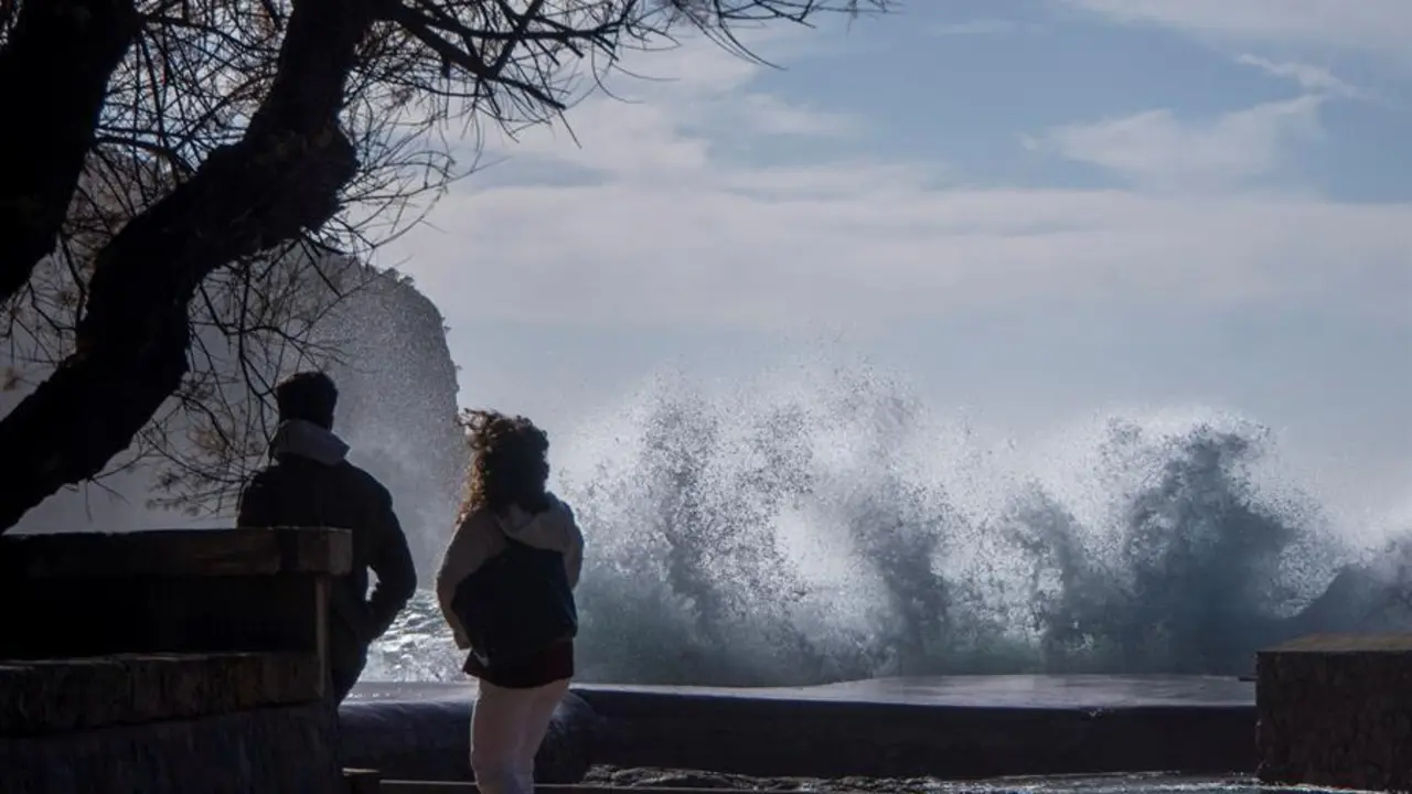 Hortensia, la borrasca atl&aacute;ntica que desde ayer afecta a todo el pa&iacute;s, se encamina ya m&aacute;s atenuada hacia el este peninsular, aunque en su trayectoria ha dejado rachas huracanadas de 179 kil&oacute;metros por hora, olas de m&aacute;s de 7 metros en el litoral atl&aacute;ntico e intensas lluvias en el oeste peninsular. En la imagen, dos personas pasean por la zona tur&iacute;stica de Camp de Mar. EFE/CATI CLADERA