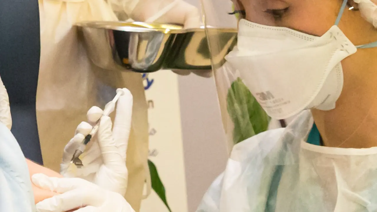 Una sanitaria del SCS administra una dosis a una paciente c&aacute;ntabra en el CAD de Cueto. / ALERTA