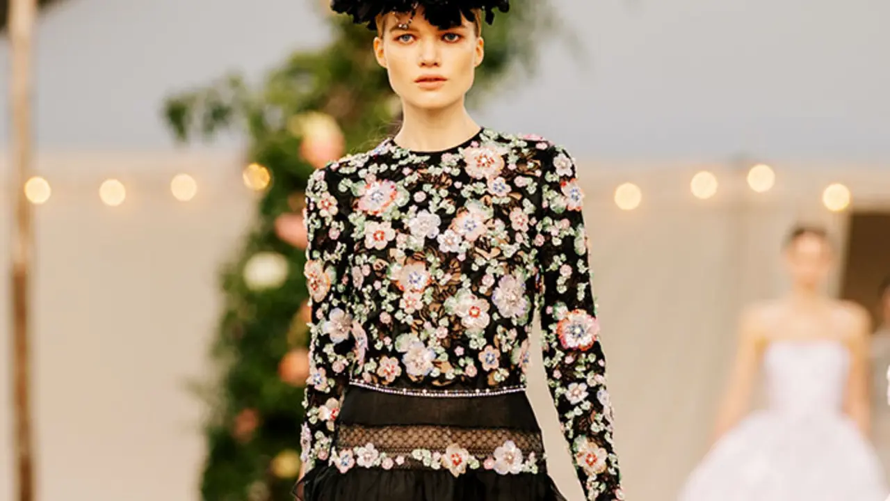 Chanel abri&oacute; la pasarela un conjunto de encaje con blusa blanca de mangas francesas y falda bohemia hasta los pies en un llamativo rosa, un contraste de colores pensado para alegrar el ambiente.