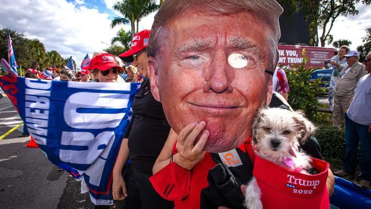 Una persona sostiene una m&aacute;scara con la imagen del presidente Donald Trump mientras espera su llegada este mi&eacute;rcoles en West Palm Beach al sureste de Florida. Donald Trump lleg&oacute; este mi&eacute;rcoles todav&iacute;a como presidente de EE.UU. a Palm Beach (sureste de Florida), antes de la asunci&oacute;n presidencial de Joe Biden en Washington, a bordo del avi&oacute;n Air Force One procedente de la base a&eacute;rea Andrews, en Maryland, a las afueras de Washington. EFE/Giorgio Viera