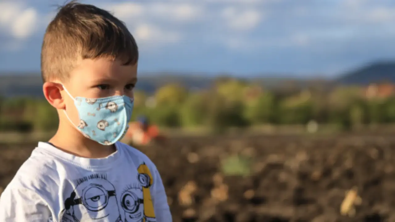 Un ni&ntilde;o con mascarilla en la salida de un colegio.