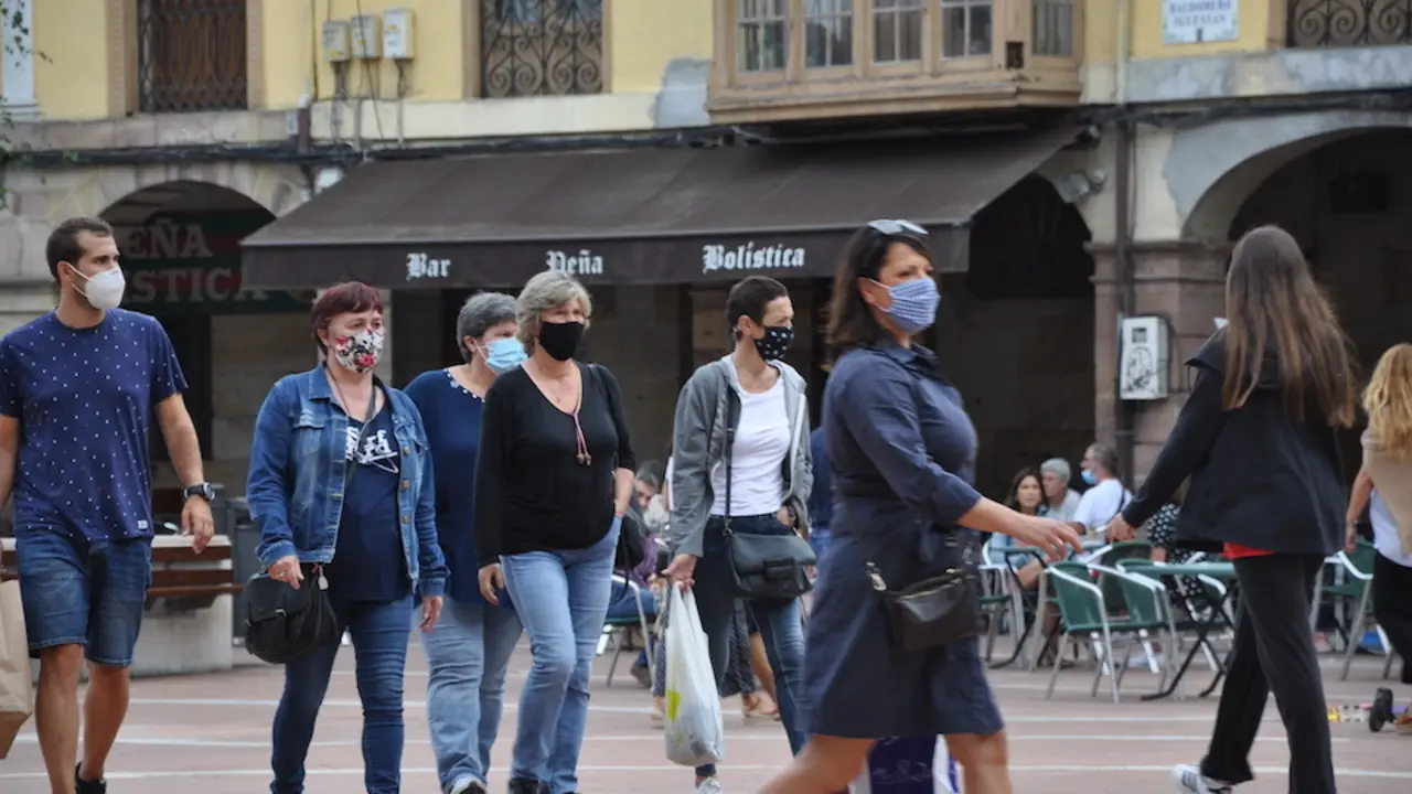 Varias personas transitan con mascarilla por la plaza roja de Torrelavega. / S.D.