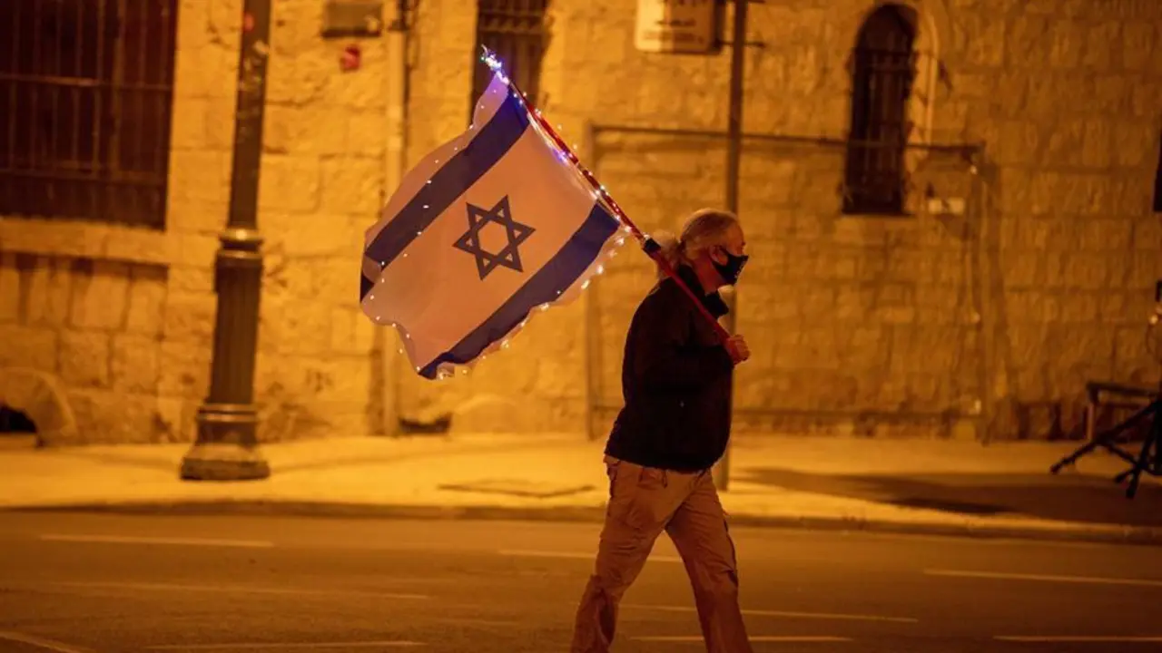 Un manifestante israel&iacute; sostiene la bandera israel&iacute; durante una protesta frente a la residencia del primer ministro israel&iacute;, en Jerusal&eacute;n, Israel, el 6 de febrero de 2021. El primer ministro israel&iacute; Netanyahu se enfrenta a un juicio en curso por cargos de fraude, soborno y abuso de confianza, su juicio est&aacute; programado para el 08 de febrero en el tribunal de distrito de Jerusal&eacute;n. (Protestas, Estados Unidos, Jerusal&eacute;n) EFE/EPA/ATEF SAFADI