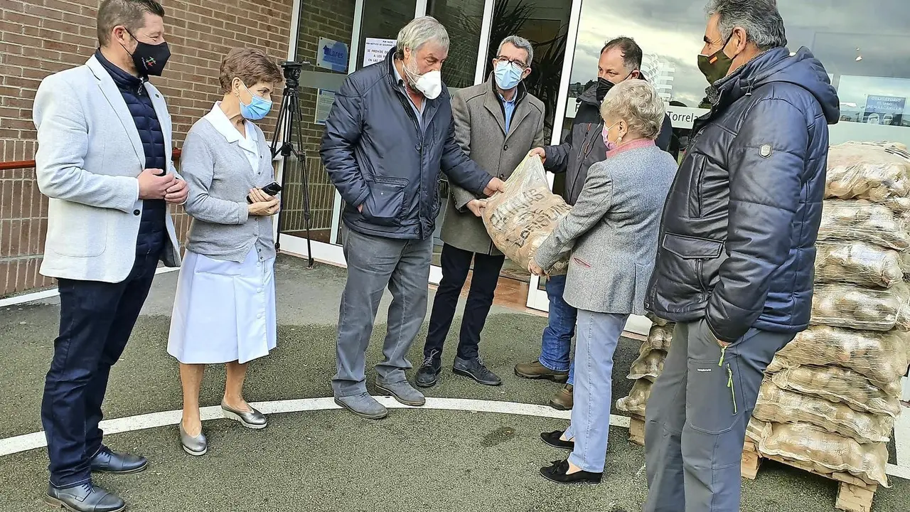 El alcalde de Valderredible y representantes del Ayuntamiento de Torrelavega durante la entrega de las patatas. / ALERTA