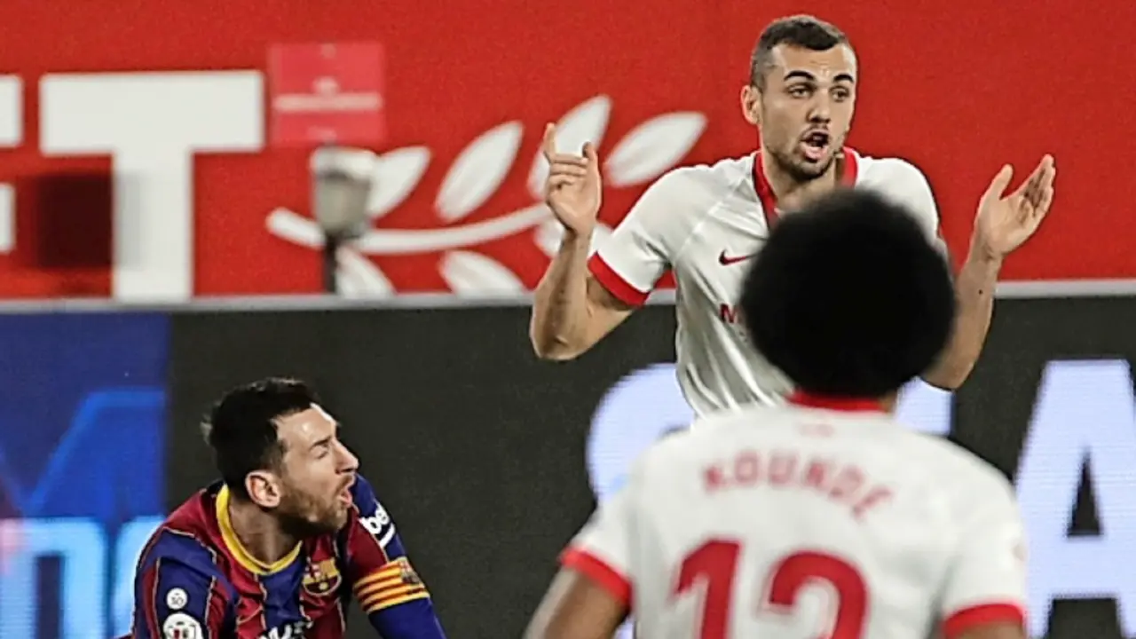 Leo Messi  cae ante el centrocampista del Sevilla, Joan Jord&aacute;. / Julio Mu&ntilde;oz
