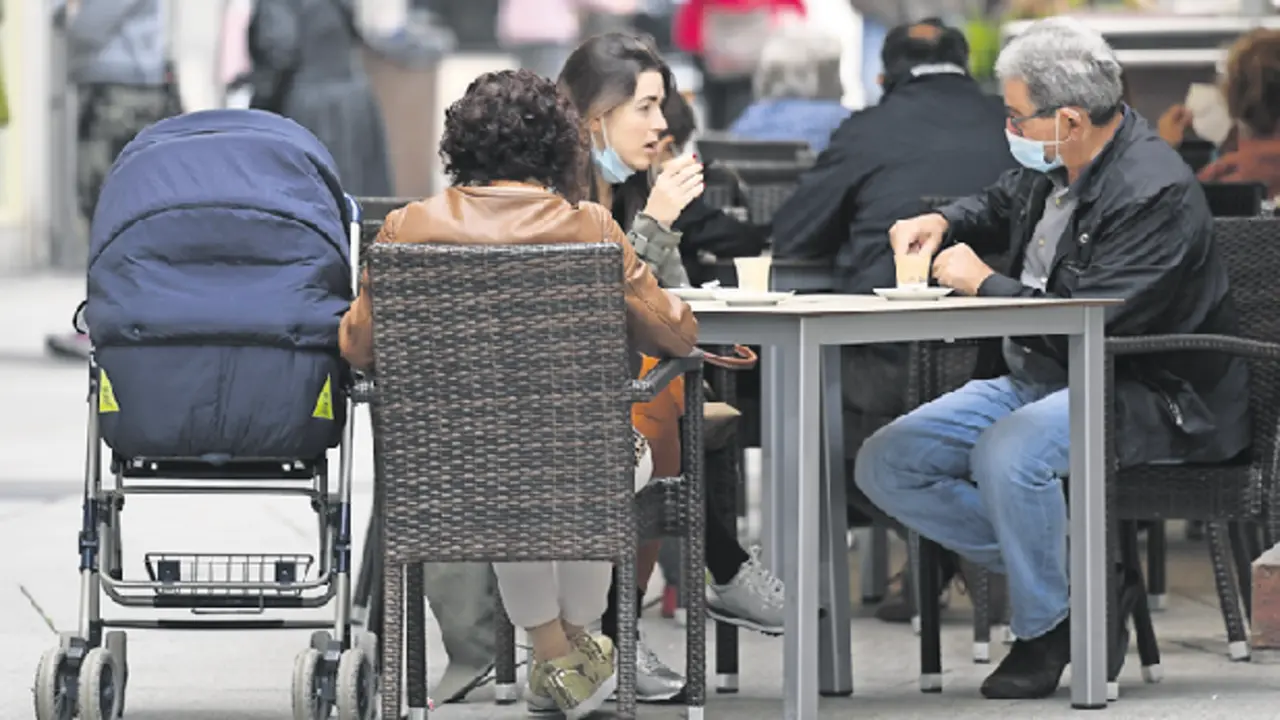 Varios ciudadanos con la protecci&oacute;n de la mascarilla en una terraza del centro de Santander. / Hardy