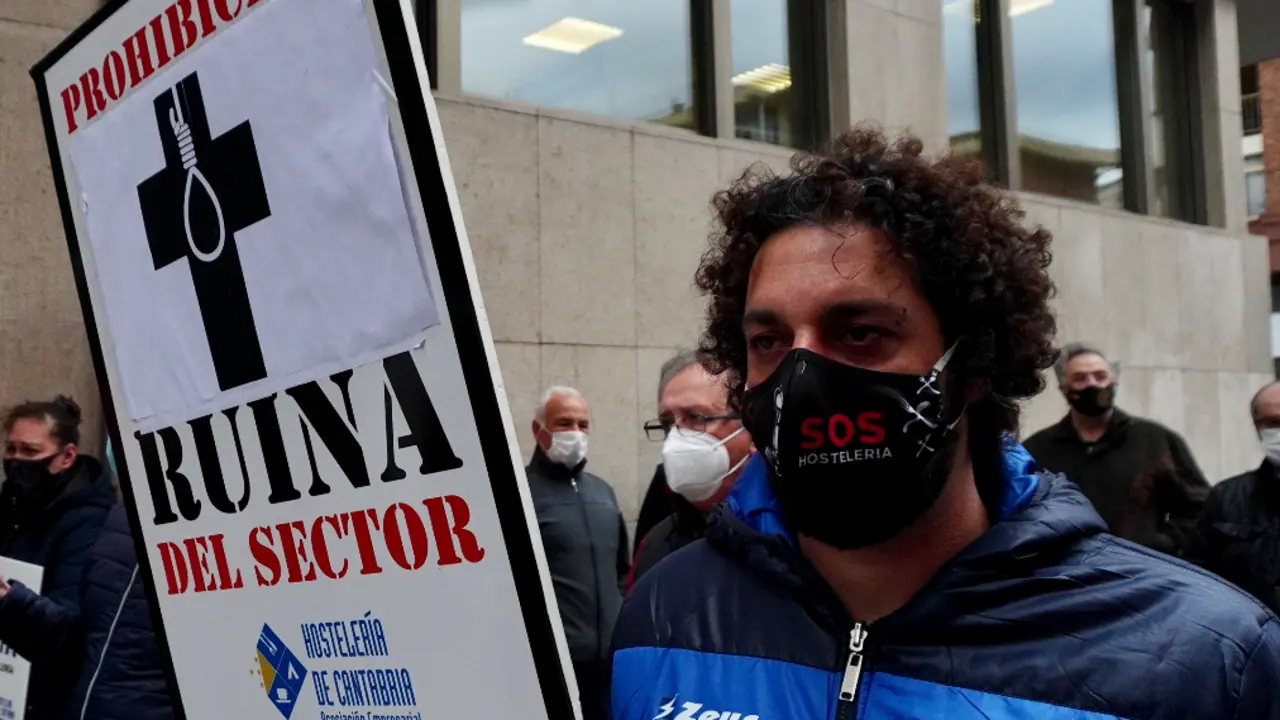 Un hostelero sostiene un cartel de denuncia ante la Consejer&iacute;a de Sanidad en la &uacute;ltima manifestaci&oacute;n del sector. / HARDY