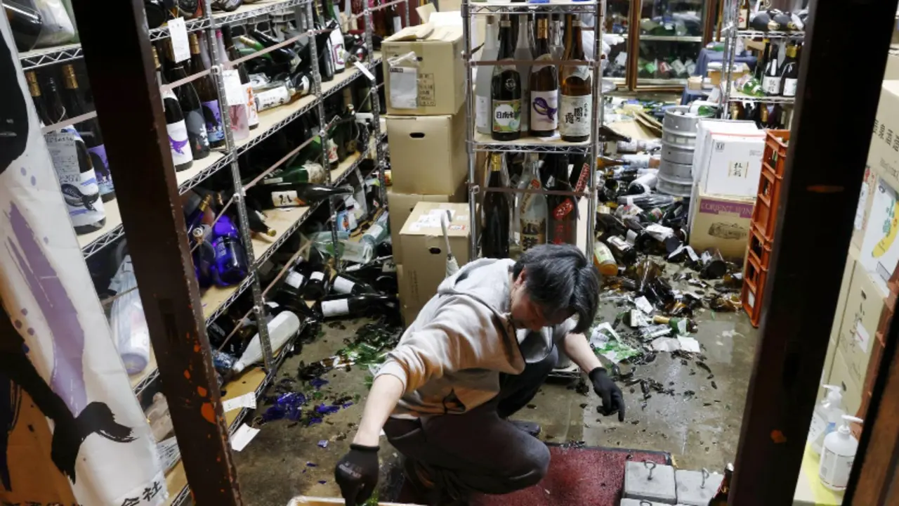 El gerente de una licorer&iacute;a en la ciudad de Fukushima limpia tras el terremoto del s&aacute;bado por la noche.