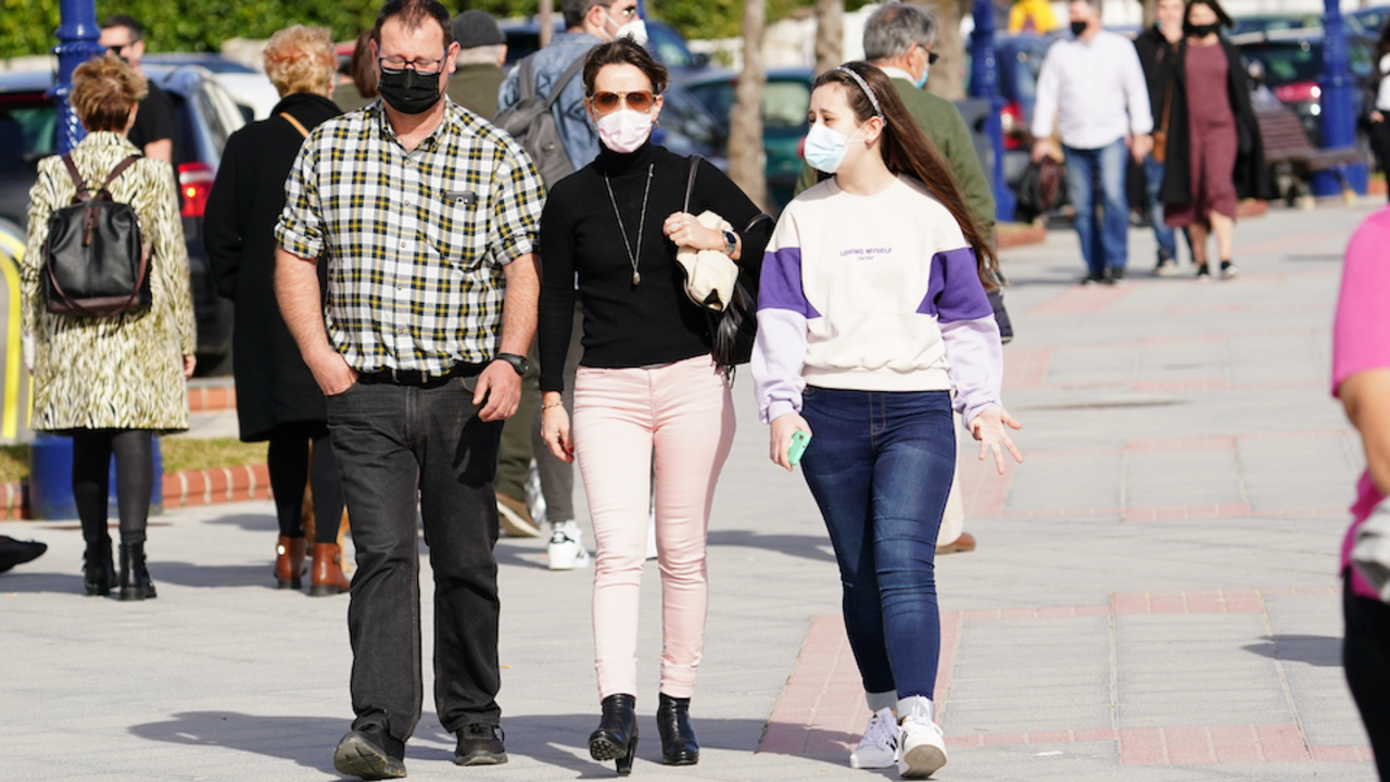 Varias personas con mascarilla caminan por las inmediaciones de la playa del Sardinero en Santander. / Hardy
