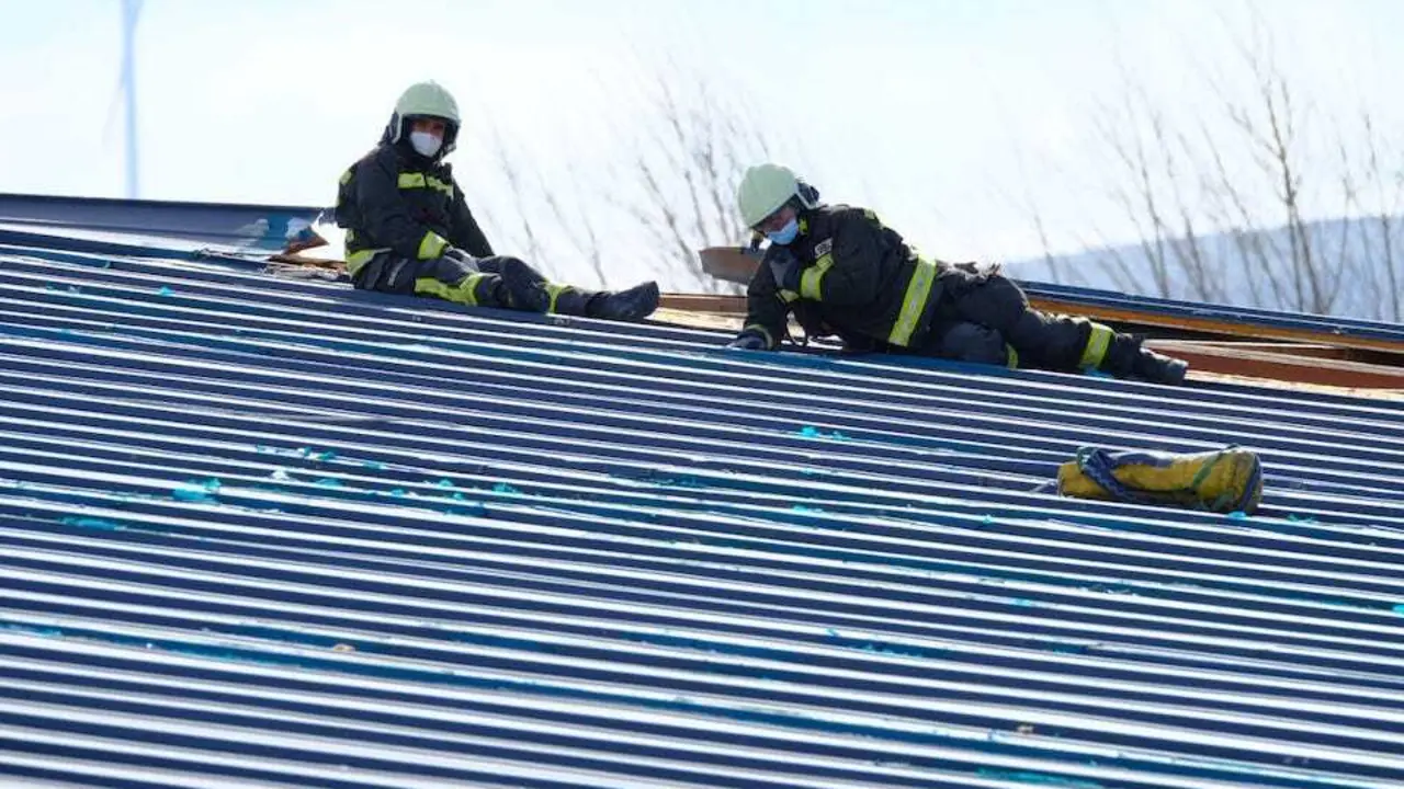 Los bomberos arreglan los desperfectos en la piscina cubierta de Reinosa ocasionados por el viento. / E. MART&Iacute;NEZ
