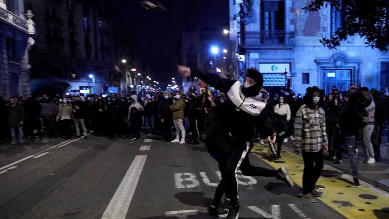 Manifestantes lanzan objetos esta noche frente a la comisar&iacute;a de V&iacute;a Layetana, en el centro de Barcelona, en una nueva manifestaci&oacute;n por la libertad de Pablo Hasel, despu&eacute;s de cinco d&iacute;as consecutivos de protestas que han finalizado con enfrentamientos con los Mossos d'Esquadra y da&ntilde;os a bienes p&uacute;blicos y privado. EFE/Alejandro Garc&iacute;a